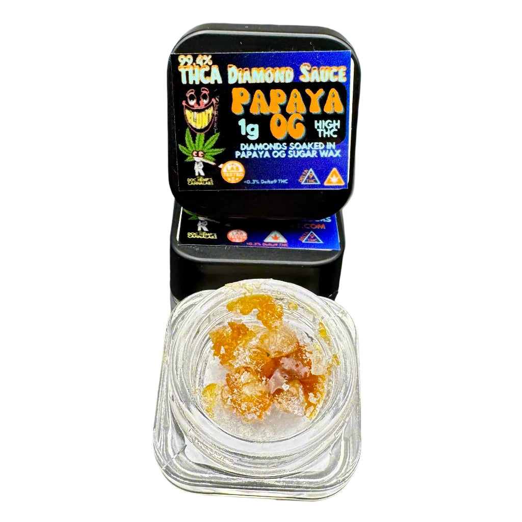 A small clear container holding a golden-brown cannabis concentrate, labeled as 'THCA Diamond Sauce Papaya OG', set against a beach backdrop with palm trees.