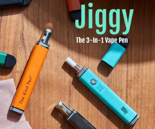 Jiggy Pen wax and vape pen in colors baby blue orange and black on wooden background