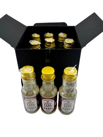Three small bottles with gold caps and labels in a black box on a white background