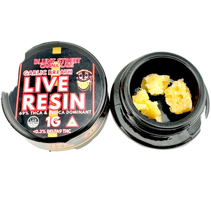Black container of live resin with visible cannabis resin on a gray background