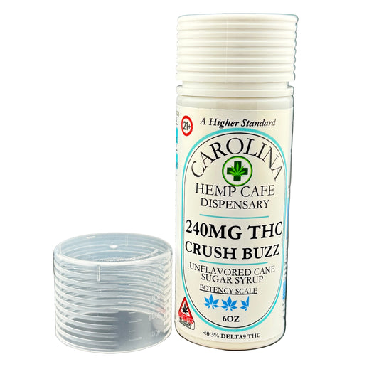 Bottle of Carolina Hemp Cafe Dispensary syrup with a clear container on a gray background