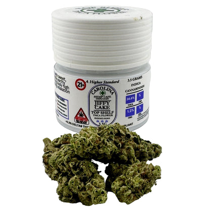 Jar of Carolina Hemp Farms Jiffy Cake with cannabis buds on a white background