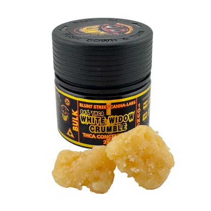 Black container of Blunt Street Canna Labs White Widow Crumble with two pieces of the product on a white background.