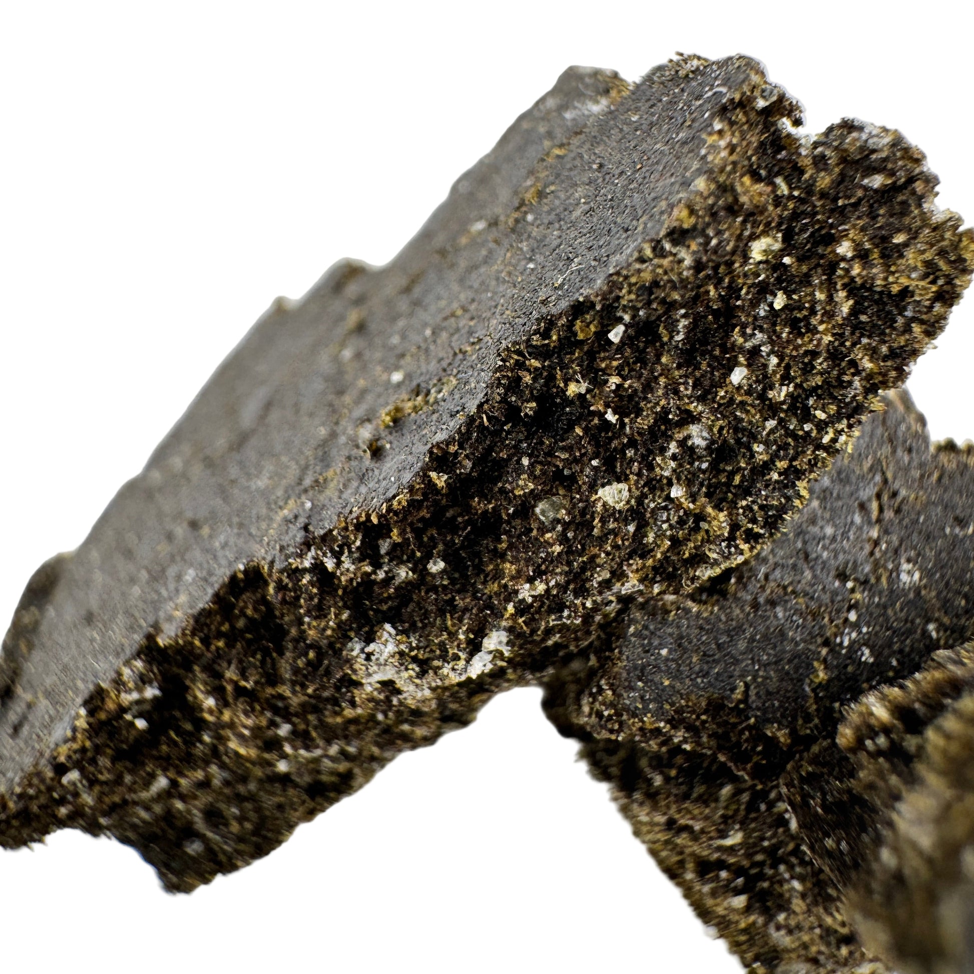 Close-up of a dark, textured mineral sample on a light background