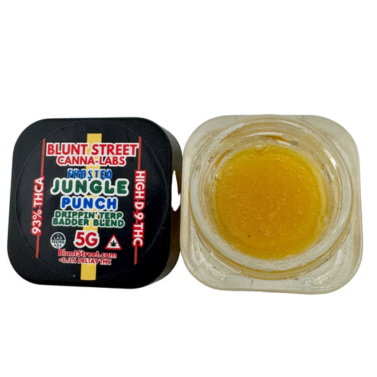 Jar of yellow substance next to a black container labeled 'Blunt Street Canna-Labs' on a white background