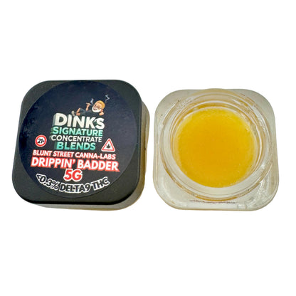 Jar of yellow substance with Dinks branding on a gray background