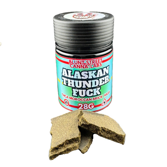 Jar of 'Alaskan Thunder Fuck' cannabis product with packaging on a gray background