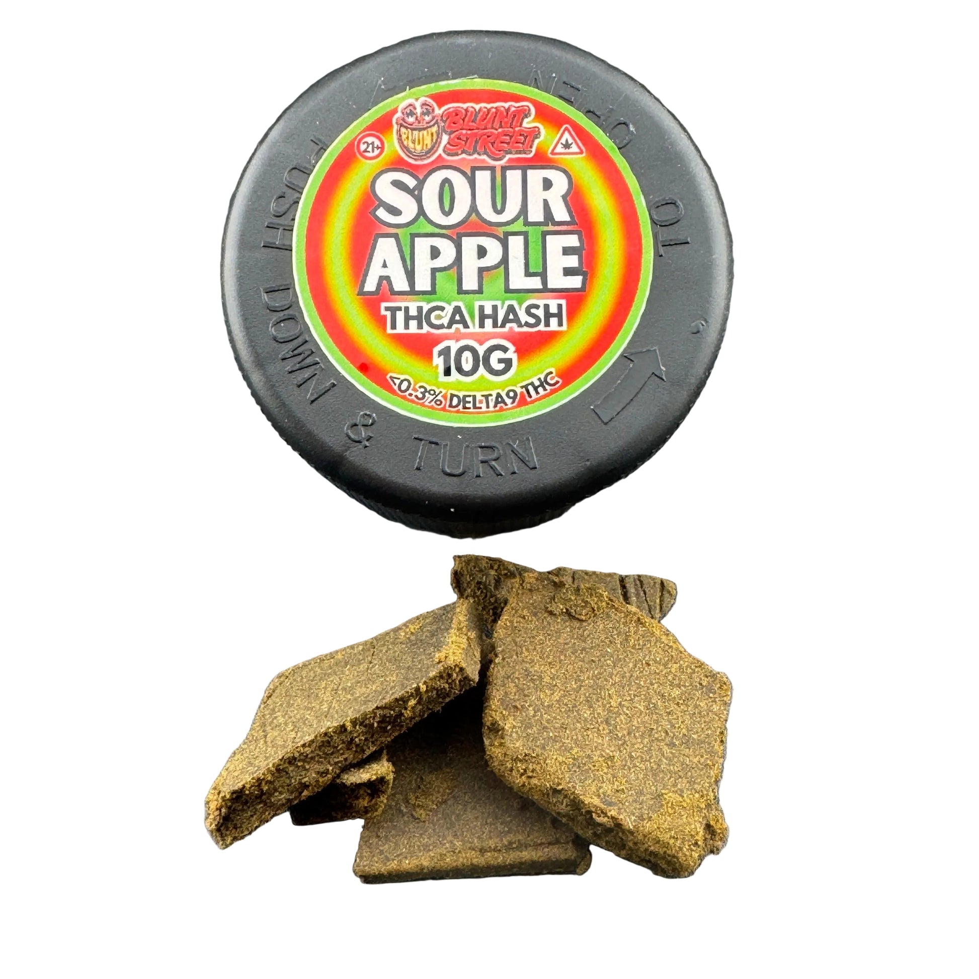 A round black container labeled 'Bung Rush Sour Apple Thca Hash 10G' sits on a dark gray surface with several broken brown hash pieces in front.