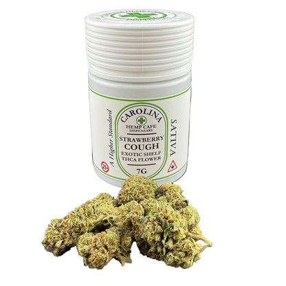 A white plastic jar of Carolina Hemp Cafe Exotic Shelf Strawberry Cough Exotic Shiel Thica Flower with a pile of dried green and orange cannabis buds in front, set against a dark gray background.