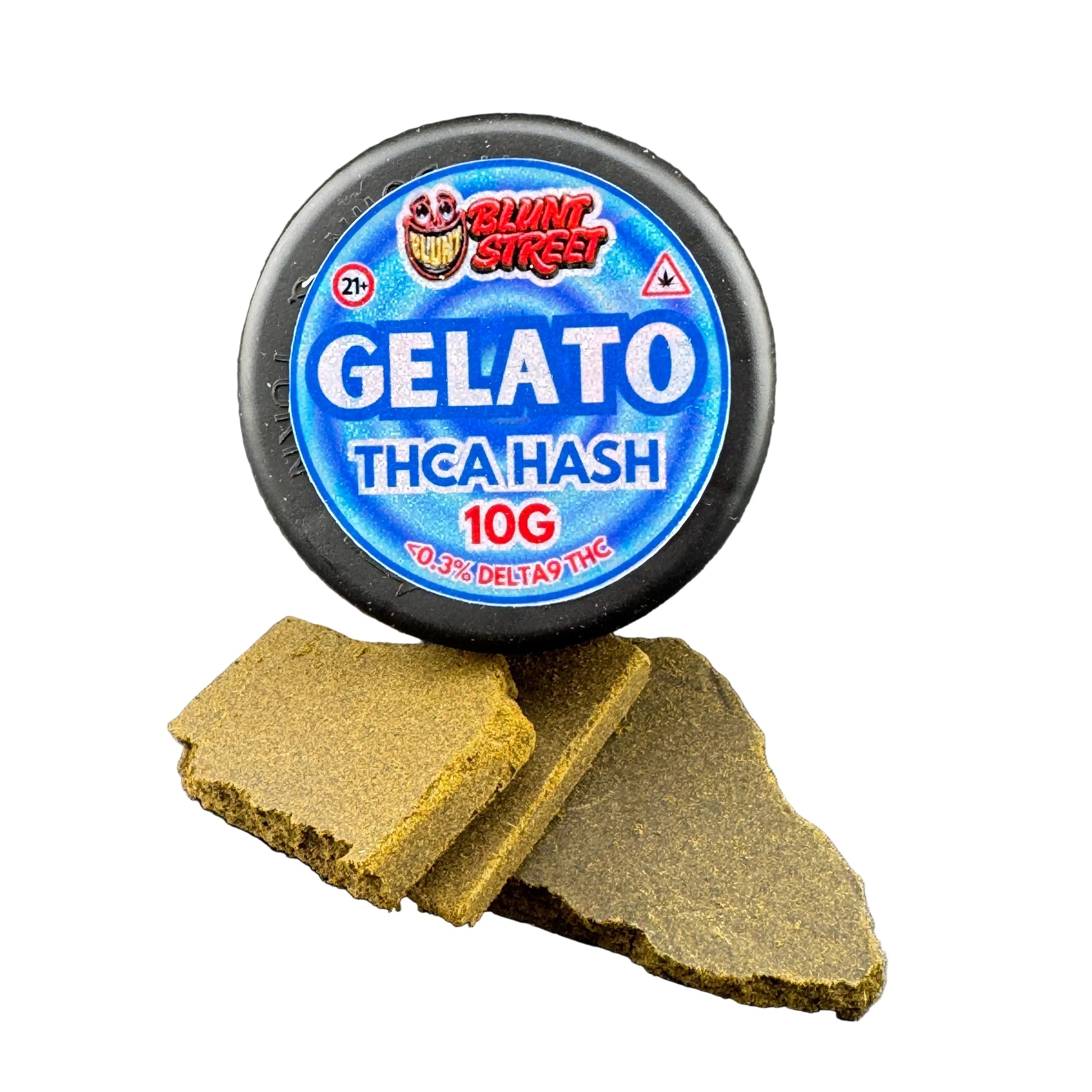A round black container labeled 'BLUNT STREET GELATO THCA HASH 10G' sits on a dark gray surface with two broken pieces of the brownish-green hash in front.