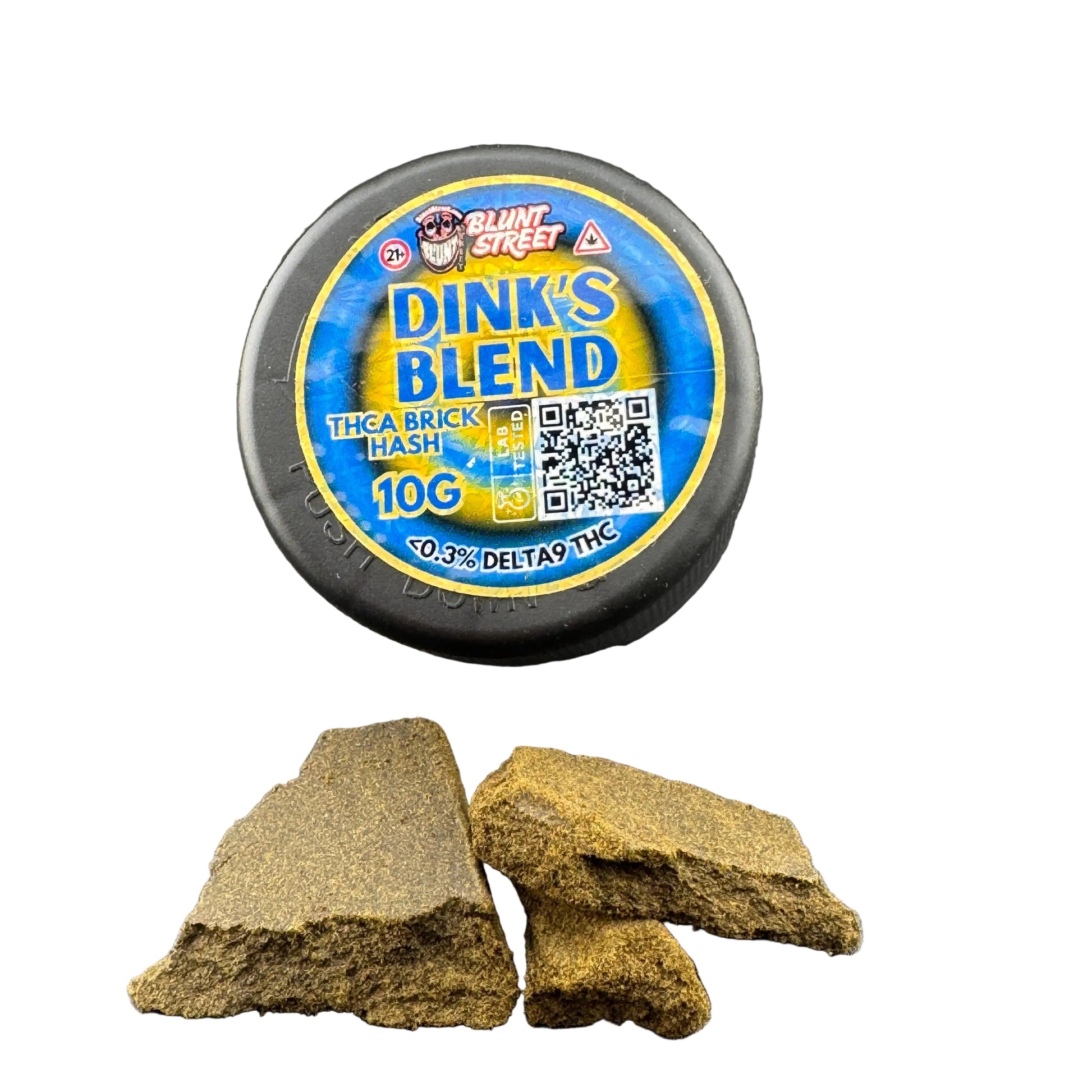 A round black container of Blunt Street Dink's Blend fishing bait is shown on a dark gray surface, with two broken pieces of the tan-brown bait placed in front. The label is blue and yellow with product details including 'Tha Brick Wash' and '10G'.