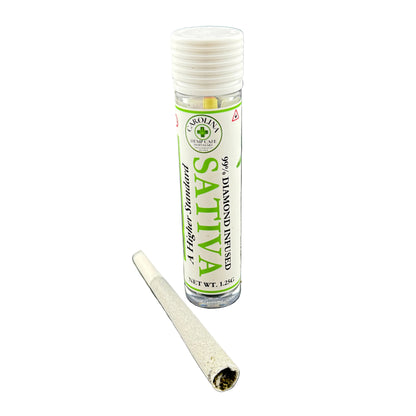 A clear cylindrical rolling paper tube with a white cap and a white label reading 'Sativa' and '99% Diamond Free,' shown next to a rolled paper cone on a plain white background.