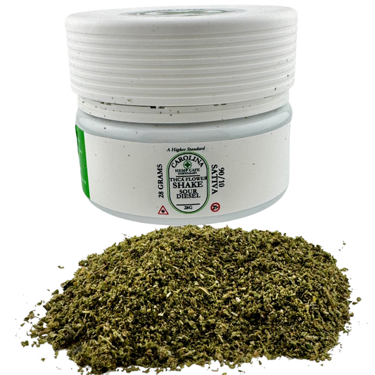 White container with green label and dried herbs on a white background