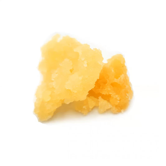 Two pieces of yellow thca crumble on a white background